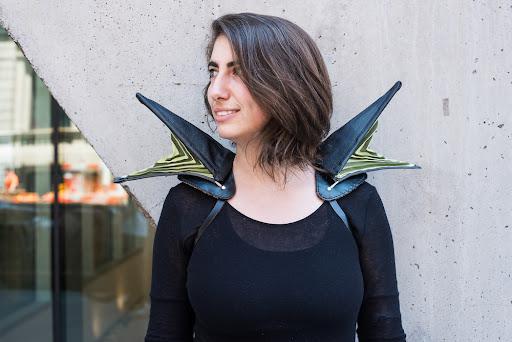 Photo of a woman wearing wing-like extrusions on her shoulders